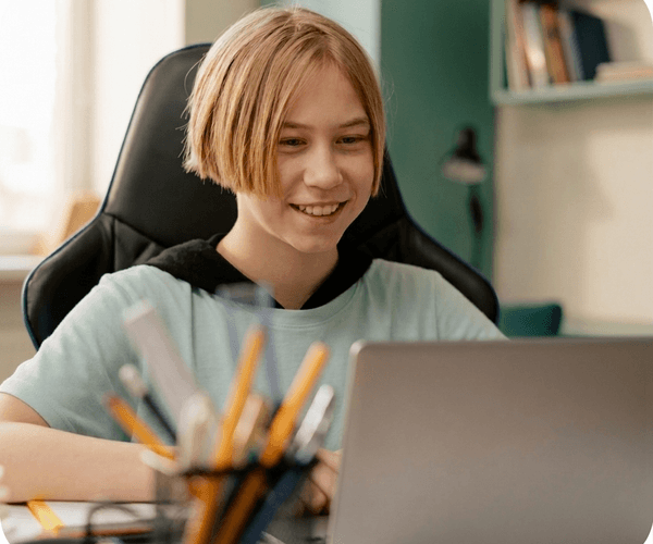 Student smiling while working on a laptop
